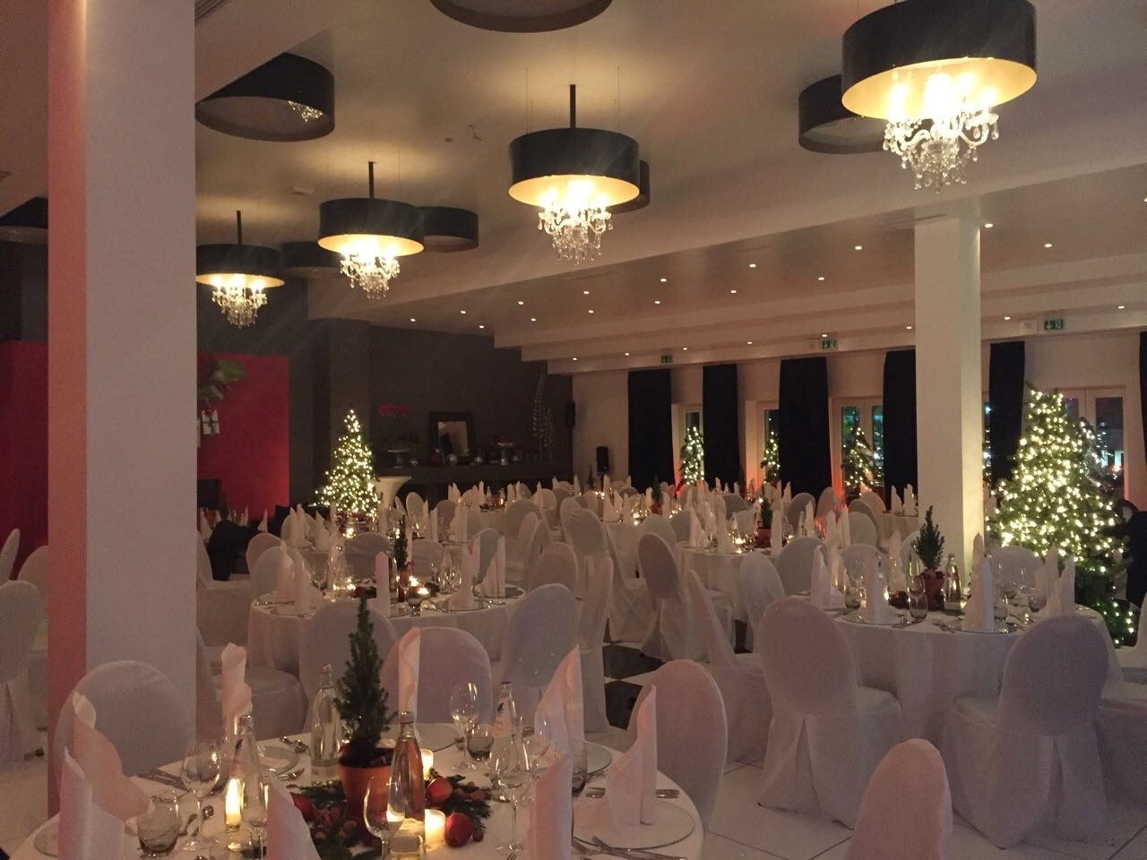 Festlich gedeckter Saal mit Weihnachtsbäumen bei einer Firmen-Weihnachtsfeier von Lehrieder